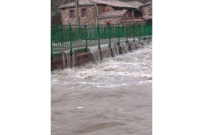 El agua del río pasa por encima del puente en Villasimpliz de Gordón. Agustín Hernández Gago.