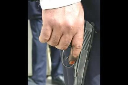 Un policía empuña un pistola con sus dedos aún manchados después de votar. La relación entre lo militar y lo político fue muy estrecha durante todo el día.