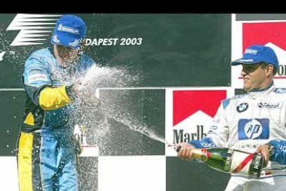 El piloto colombiano de BMW, Juan Pablo Montoya, que quedó tercero en la clasificación, 'riega' a Alonso con champang.