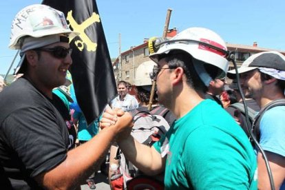 Dos mineros de León y Asturias se dan la mano. Norberto