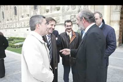 El candidato socialista a la alcaldía de León, Francisco Fernández (con una gabardina clara) y el candidato también del PSOE a la Junta, Ángel Villalba, saludan al presidente de Caja España, Santos Llamas, antes del comienzo del acto.