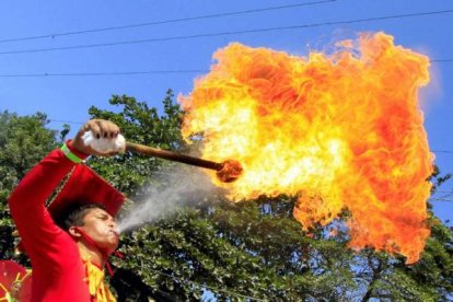 Un hombre saca fuego por la boca durante su participación en el Carnaval de Barranquilla. Foto: EFE/RICARDO MALDONADO ROZO