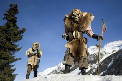 Dos participantes en el carnaval de máscaras en Suiza. Foto: EFE/Jean-Christophe Bott
