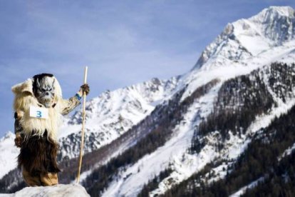 Un participante en el carnaval de máscaras, camina en las calles de la aldea de Wiler en el valle de Lötschental (Suiza). Foto: EFE/Jean-Christophe Bott