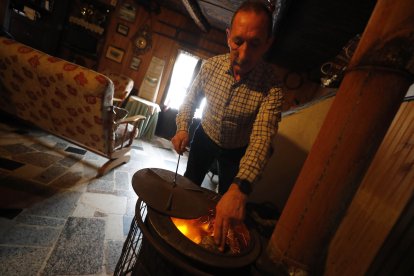 Abel echa leña a la estufa para tener el salón caliente. ANA F. BARREDO