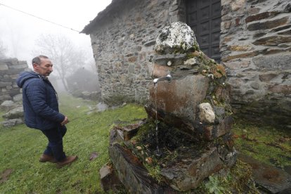 Abel junto a una de las fuentes del pueblo y la antigua escuela, restaurada, detrás. ANA F. BARREDO