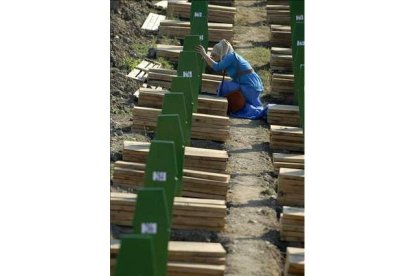 Una mujer reza ante una de las tumbas del centro memorial de Potocari, cerca de Srebrenica. SULEJMAN OMERBASIC | AP