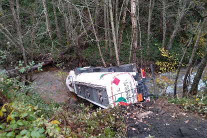 Bomberos y operarios de Tragsa continúan trabajando en la zona para determinar la mejor manera de sacar el camión sin peligro de vertido. BOMBEROS PONFERRADA