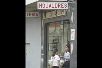Dos jóvenes disfrutan de los manjares de una de las fábricas de hojaldres y mantecadas de Astorga, productos típicos de la ciudad.