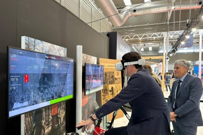 El consejero de Medio Ambiente, Vivienda y Ordenación del Territorio, Juan Carlos Suárez-Quiñones, prueba la realidad virtual para conocer dos rutas de la Zona Alfa León compañado por el delegado de la Junta, Eduardo Diego, en la feria de turismo Intur. DL