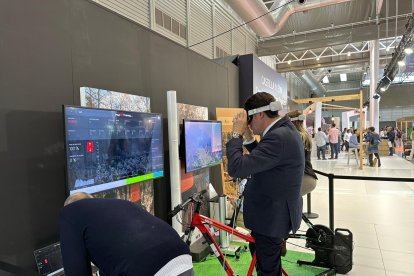 El consejero de Medio Ambiente, Vivienda y Ordenación del Territorio, Juan Carlos Suárez-Quiñones, prueba la realidad virtual para conocer dos rutas de la Zona Alfa León compañado por el delegado de la Junta, Eduardo Diego, en la feria de turismo Intur. DL