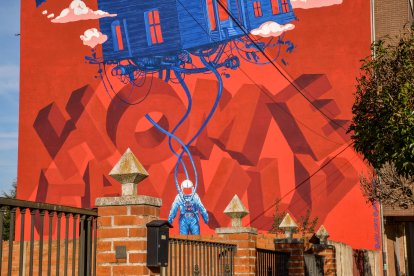 Artista: Javi 'Corte' Landa
Título: Home family
El barrio en el que se encuentra el mural es un barrio obrero lleno de pequeños negocios y pequeña tiendas familiares, esa característica nos inspiró para crear este mural.
Intentamos representar metafóricamente ese lazo de unión entre hijos/as y padres/madres…. De las personas con su familia y su herencia. Una herencia y una conexión que muchas veces nos ayuda ya que nos provee de trabajo y seguridad. Pero también nos puede frenar y cortar las alas en nuestras aventuras y desarrollo personal.
El astronauta que arrastra su casa, simboliza esa persona que quiere explorar pero le guste o no, tiene ese hogar detrás de si, un hogar que le cobija pero a la vez un hogar con responsabilidades y expectativas puestas en el/ella.