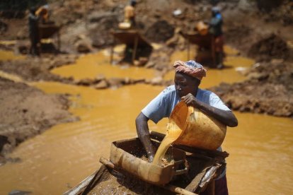 Una mujer mezcla agua con mena y mercurio en una mina en Macalder en el condado de Migori al oeste de Kenia. DAI KURUKAWA