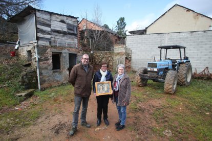 El alcalde de Arganza, Javier Ovalle, con su madre y nieta de Avelino Fernández Peral, María del Carmen Villar y con Cecilia Yáñez, otra nieta de que fue regidor en 1936, junto al cobertizo donde estuvo el horno que sirvió de escondite al hombre que presidía el Ayuntamiento cuando estalló la Guerra Civil. María del Carmen sostiene un retrato de Avelino y su esposa Cecilia Fernández.  L. DE LA MATA