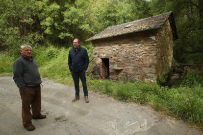 El pedáneo de Espanillo,  el exminero de la MSP Alfredo Lago, y el alcalde de Arganza, Javier Ovalle, en el exterior del molino harinero del pueblo. 