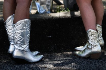 Fans con botas imitando el estilo de Taylor Swift antes de entrar a uno de sus conciertos. EFE/EPA/TIAGO PETINGA