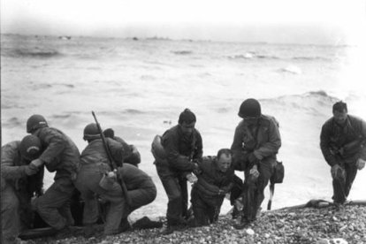Soldados estadounidenses que ayudan a sus compañeros heridos en la playa Utah durante el desembarco de Normandía (Francia) el 6 de junio de 1944.