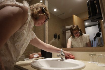 Virginia limpia el baño.