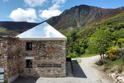 El tejado de aluminio-espejo atrapa las nubes en el antiguo economato del poblado de La Piela, reconvertido en el centro de visitantes La Montaña Negra