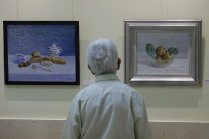 Uno de los asistentes a la exposición observando los cuadros. FERNANDO OTERO