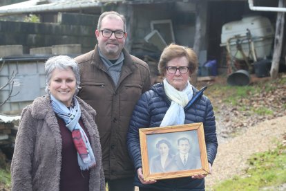 Cecilia Yáñez, Javier Ovalle y Mari Carmen Villar, en enero en el lugar donde Avelino Fernández se escondió en el estiércol, con la foto de Avelino y su esposa Cecilia Fernández