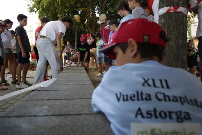 Uno de los niños afina su puntería con las chapas. FERNANDO OTERO