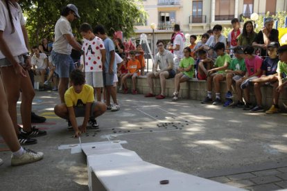 Uno de los niños afina su puntería con las chapas. FERNANDO OTERO