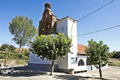 La iglesia de Valdelafuente y vista del pueblo de Arcahueja. Abajo, unos peregrinos surcan este tramo del Camino.