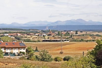 La iglesia de Valdelafuente y vista del pueblo de Arcahueja. Abajo, unos peregrinos surcan este tramo del Camino.