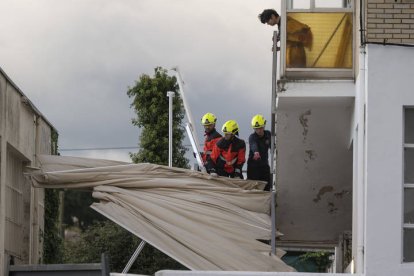 Bomberos de Santander retiran un toldo caÍdo por el viento.