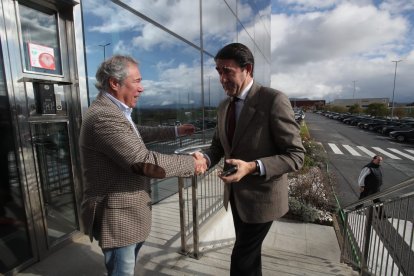 El consejero saluda al director de Diario de León, Joaquín S. Torné, encargado de moderar la mesa.