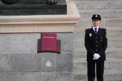 Una agente de policía monta guardia junto a un ejemplar de la Constitución durante celebración del Día de la Constitución en el Congreso de los Diputados en Madrid, este viernes. EFE/ Borja Sanchez-Trillo