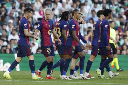 El delantero polaco del FC Barcelona Robert Lewandowski (i) celebra con sus compañeros tras marcar el 0-1 durante el partido de la jornada décimo sexta de LaLiga EA Sports que disputan Real Betis Balompié y FC Barcelona en el Estadio Benito Villamarín de Sevilla. EFE/ Julio Muñoz