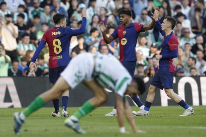 (i-d) Los jugadores del FC Barcelona Pedri, Lamine Yamal y Marc Casadó celebran el 0-1 durante el partido de la jornada décimo sexta de LaLiga EA Sports que disputan Real Betis Balompié y FC Barcelona en el Estadio Benito Villamarín de Sevilla. EFE/ Julio Muñoz