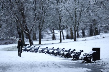 Un ciclista pasa junto a una fila de bancos cubiertos de nieve en Sefton Park en Liverpool, Gran Bretaña, el 5 de enero de 2025. EFE/EPA/ADAM VAUGHAN