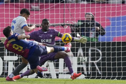 El delantero del FC Barcelona Robert Lewandowski (delante), tira a portería ante el portero del Alavés, Jesúa Owono, y del defensa del Alavés Santiago Mouriño (i), durante el partido de LaLiga entre el FC Barcelona y el Alavés este domingo en el Estadio Olímpico de Montjuic en Barcelona. EFE/ Alejandro García