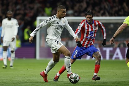 El delantero francés del Real Madrid Kylian Mbappé (i) se escapa del argentino Rodrigo de Paul, del Atlético de Madrid, durante el partido de vuelta de los octavos de final de la Liga de Campeones en el estadio Metropolitano. EFE/Juanjo Martín