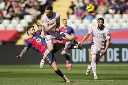 El defensa del Barcelona Íñigo Martínez y el centrocampista del Girona Viktor Tsygankov, durante el partido de la jornada 29 de LaLiga que FC Barcelona y Girona disputan este domingo en el estadio Lluis Companys de Barcelona. EFE/ Alberto Estévez