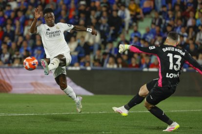 El guardameta del Getafe David Soria (d) despeja un balón junto a Vinicius Jr., del Real Madrid, durante el partido de la jornada 33 de LaLiga que Getafe CF y Real Madrid disputan hoy miércoles en el Coliseum de Getafe. EFE/Mariscal