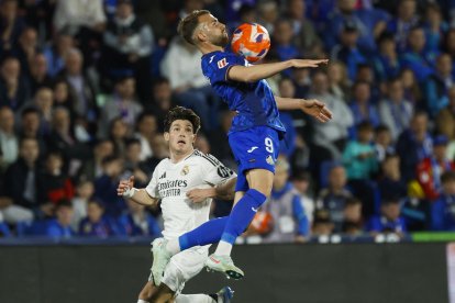 El delantero del Getafe, Borja Mayoral (d), intenta controlar el balón ante el defensa del Real Madrid, Fran García, durante el encuentro correspondiente a la jornada 33 de Laliga EA Sports que disputan hoy miércoles Getafe y Real Madrid en el Coliseum de la localidad madrileña. EFE / Juanjo Martín.