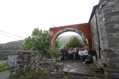 Nuevos y viejos vecinos de Santa Marina de Torre posan bajo el arco de la desaparecida iglesia de Santibáñez de Montes trasplantado al templo del pueblo.