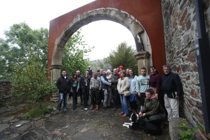Nuevos y viejos vecinos de Santa Marina de Torre posan bajo el arco de la desaparecida iglesia de Santibáñez de Montes trasplantado al templo del pueblo.