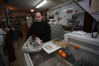 Macu distribuye el Diario de León en papel entre el vecindario.