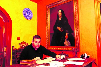 Esteban Álvarez Castañón, descendiente y responsable del archivo de los Tusinos en el despacho con el retrato de doña Bernarda, la madre de Manuela.
