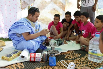 Los niños siguen con atención el ritual del té, acompañado por dátiles del desierto.