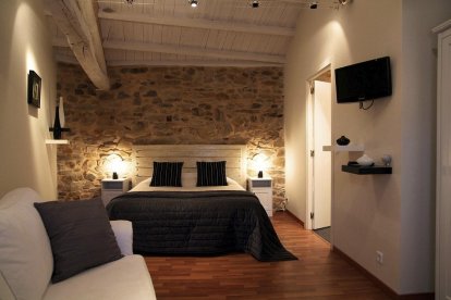 Una de las habitaciones de a-ti, que combina muros de piedra originales con confort contemporáneo.