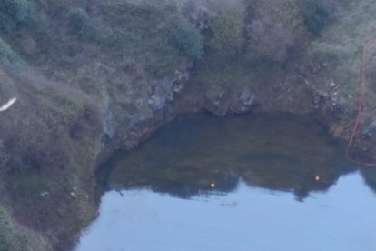 Medios acuáticos exploran en la balsa la zona donde se buscan los coches.