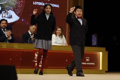 Aisha Solange (i) y Gorka Calderón (d), cantan un cuarto premio, el 78.477, que ha sido agraciado con un cuarto premio en el Sorteo de la Lotería de Navidad
