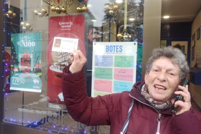 Una mujer muestra un décimo premiado con el Gordo en Villablino.