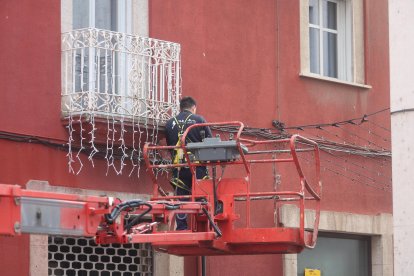 Un operario quitando las luces de Navidad de Ponferrada